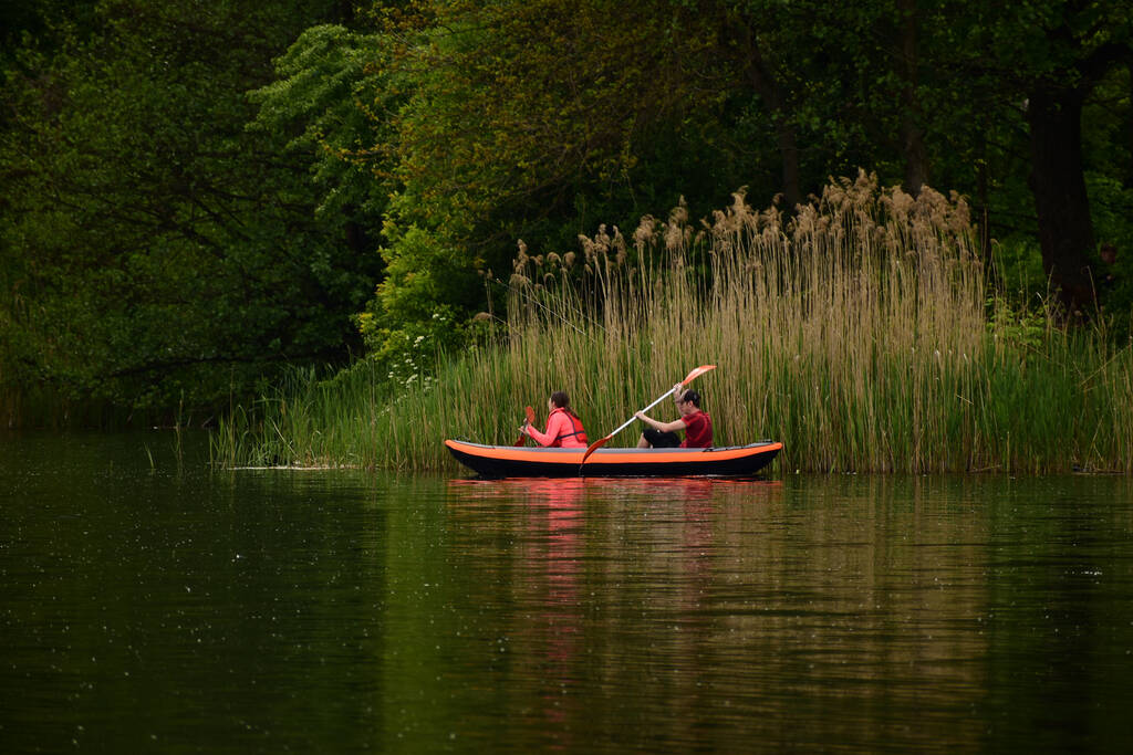 двое людей плывут на взятом в прокат каяке по живописной реке Кляйне Нете